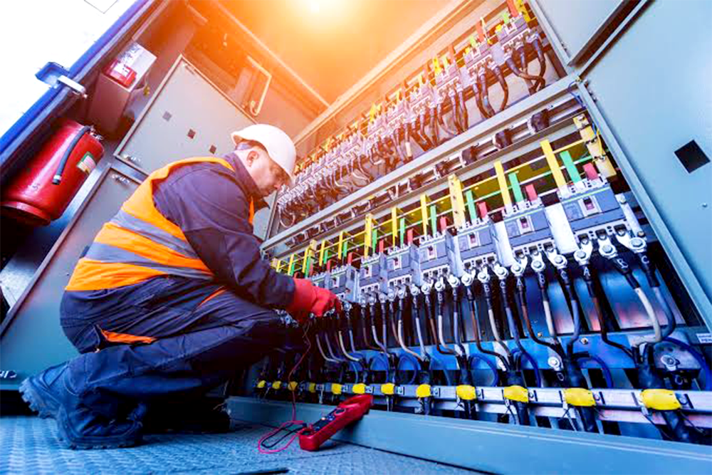 Electrical technician working on control panel